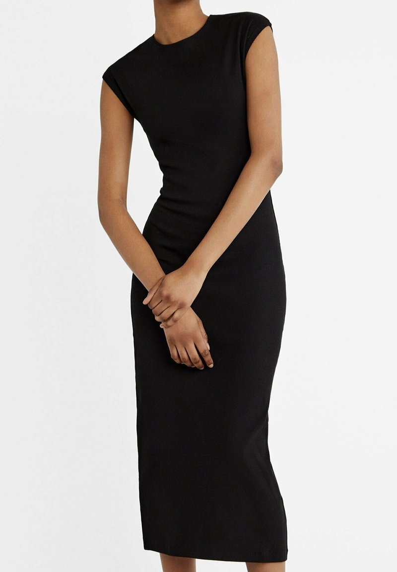 Vestito midi nero aderente con maniche a capodanno, scollatura rotonda e texture a coste. Il vestito ha una silhouette dritta e arriva a metà polpaccio.