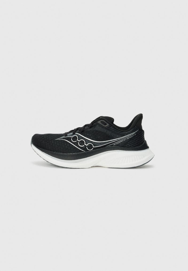 Chaussure de sport noire avec une tige en maille respirante, semelle blanche et design arrondi. Présente un logo distinctif sur le côté en blanc.