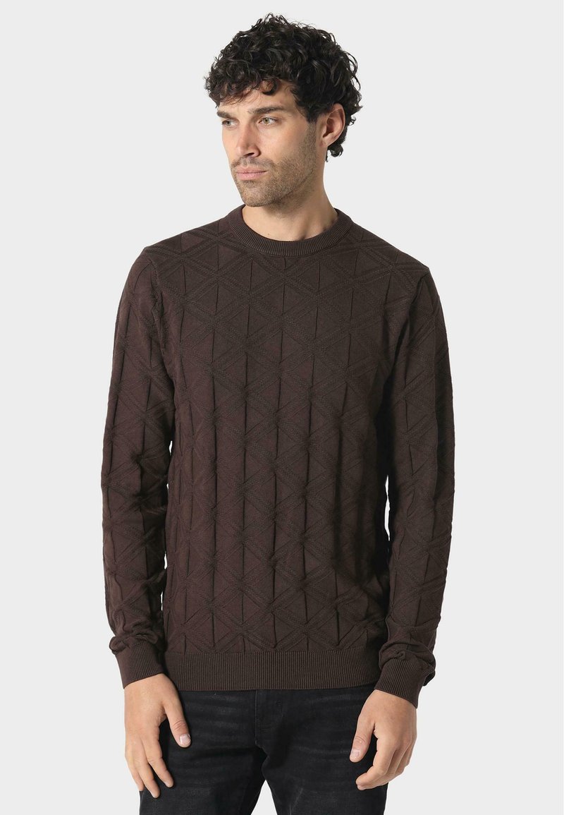 Brauner Pullover mit einem geometrischen Rautenmuster. Runder Ausschnitt, lange Ärmel und gerippte Bündchen. Der Stoff wirkt strukturiert und gestrickt.