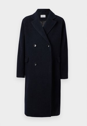Marineblauer doppelt knopfverschlossener Mantel mit geripptem Texture, mit aufgekrämpelten Revers, zwei Fronttaschen und schwarzen Knöpfen; mittellang mit gerader Silhouette.