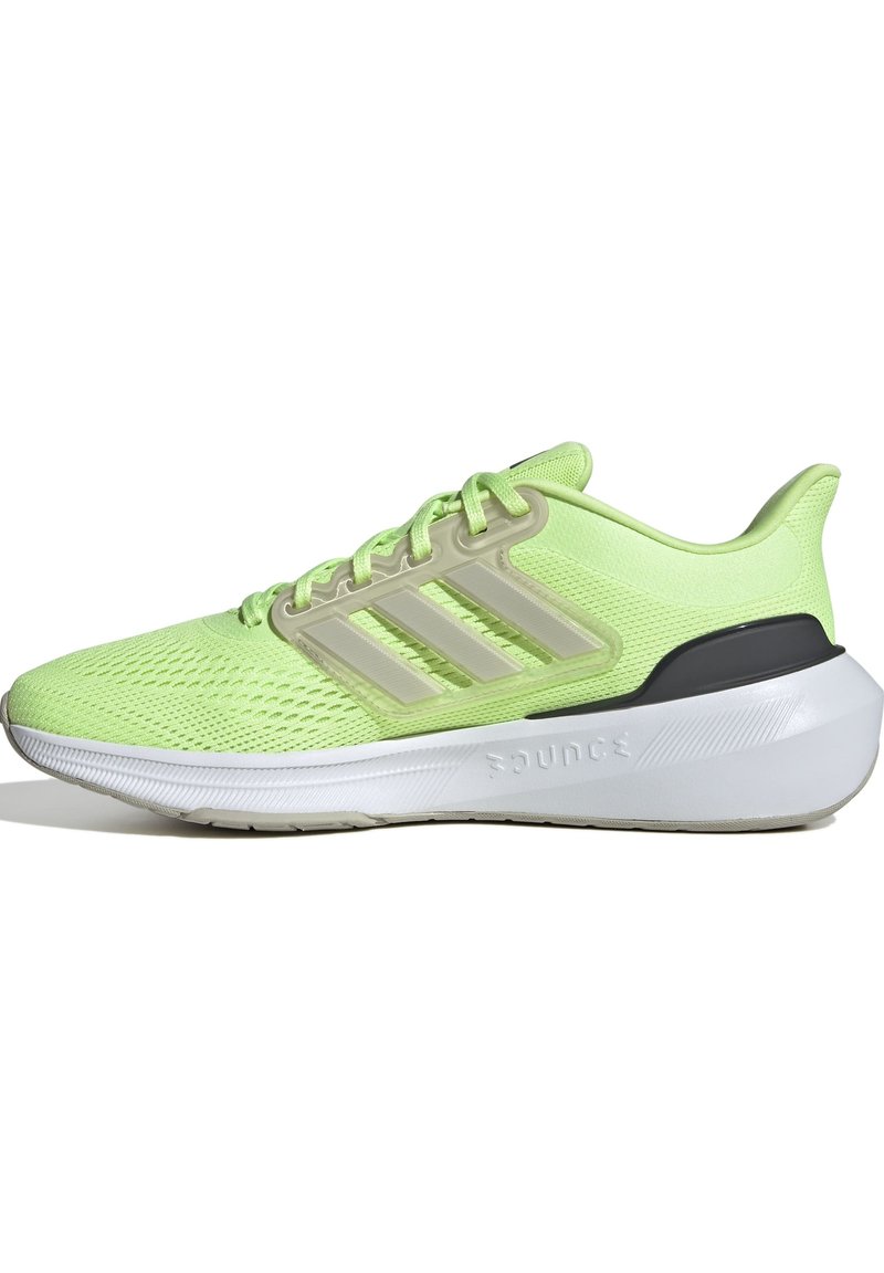 Zapatilla deportiva verde brillante con parte superior de malla, tres franjas beige, collar acolchado y una mediasuela blanca con detalles texturizados.