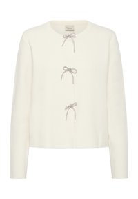 Bela kardigan iz mehkega blaga, z okroglim izrezom, dolgimi rokavi in dvema okrasnima srebrnima pentlama kot zapirala spredaj.