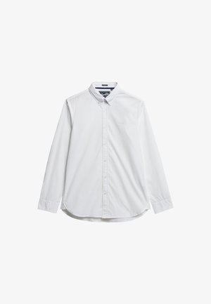 Camisa blanca de manga larga con cuello abotonado, pocos botones y un logotipo sutil en el pecho, hecha de suave tela de algodón.