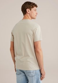 Svetlofialová krátkym rukávom tričko z mäkkého bavlneného materiálu. Okrúhly výstrih, jemná textúra, priliehavý strih, nosené s svetlomodrými džínsami.