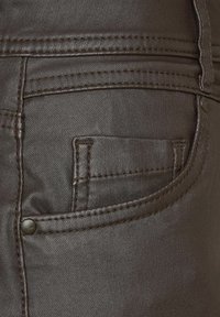 Donkerbruine denim jeans met een kleine zak, gestikte details en een metalen knoopaccent nabij de tailleband. gladde textuur.