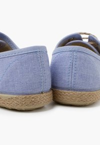 Scarpe in tela azzurro chiaro con suola in juta intrecciata, dotate di una parte posteriore arrotondata e dettagli di cucitura sottili.