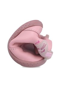 Zapato infantil rosa con parte superior de cuero suave, forma redondeada, interior acolchado y cara de gato decorativa en el talón. Presenta suela de goma perforada.
