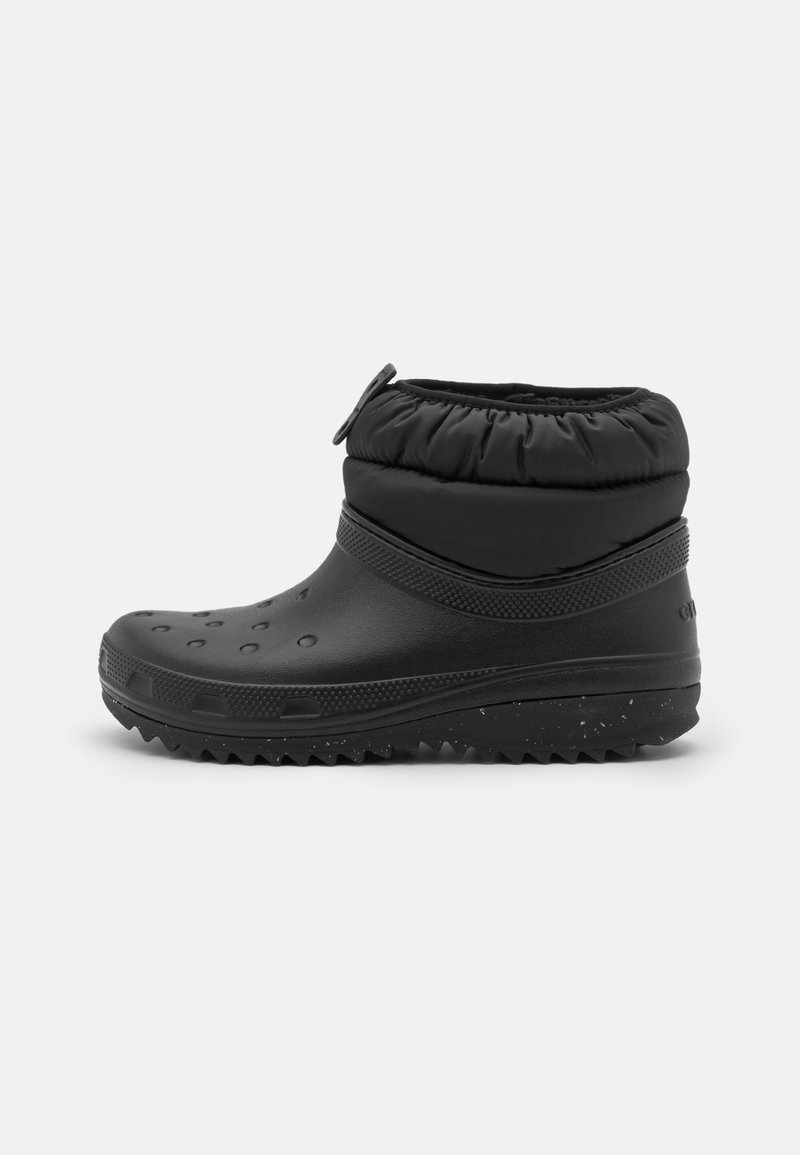 Botte noire imperméable avec une finition mate texturée, un poignet élastique et des trous de ventilation, dotée d'une semelle robuste pour une traction optimale.