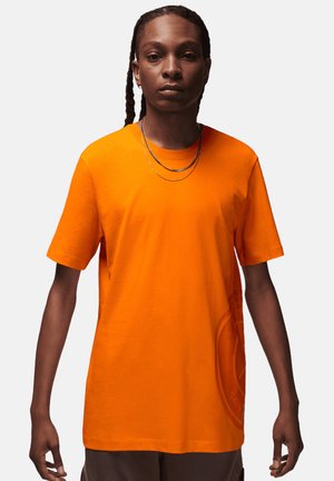 Korte mouwen t-shirt in feloranje katoen met een relaxed fit, voorzien van een ronde hals en subtiele logodetail op de voorkant.