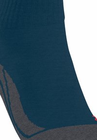 Marineblauwe sok met geribbelde textuur, grijs accentpatroon en roze logodetail. Voorzien van versterkte hiel en teen voor duurzaamheid.