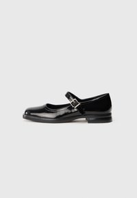 Zapato Mary Jane de charol negro con puntera redondeada, correa ajustable y tacón bajo. Textura suave y detalles mínimos.