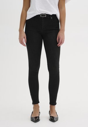 Jeans skinny neri con una trama liscia, dotati di vita media, tasche frontali e cerniere alla caviglia. Dettagli in hardware argentato semplici.