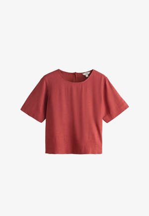 Krótka, ruda bluzka z lnu o krótkich rękawach, z okrągłym dekoltem i zapięciem na guziki z tyłu.