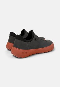 Black leather shoes with a textured finish, featuring an orange rubber sole and a low-profile design. Laces and soft collar for comfort.