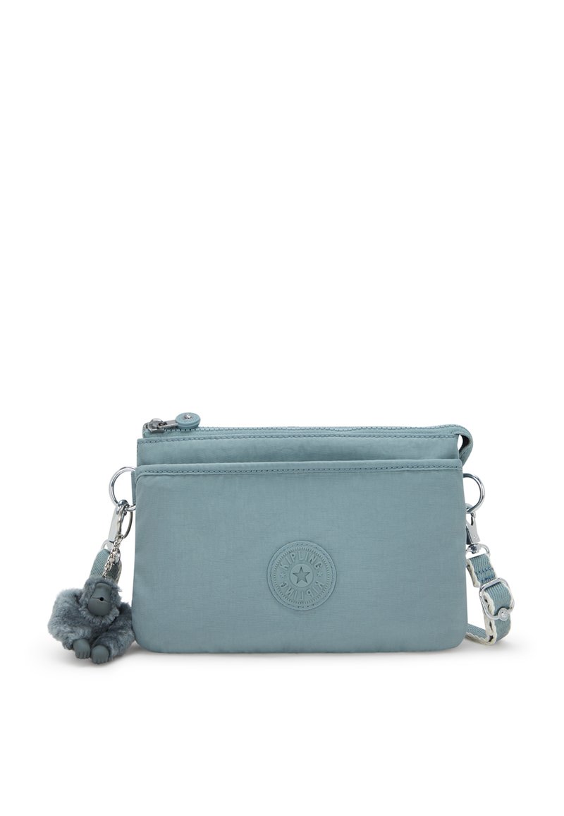 Blå stof crossbody taske med et rundt logo som accent, lynlås lukning og en dejlig abe nøglekæde. Har en justerbar rem til alsidig brug.