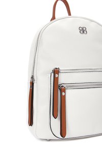 Zaino in pelle bianca con forma arrotondata, dotato di due tasche frontali con cerniera e dettagli marroni, insieme a finiture in metallo argentato. Texture liscia.