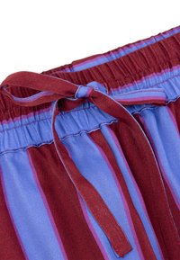 Rood en blauwe gestreepte shorts met een elastische tailleband en een gestrikt koord. De stof heeft een gladde textuur met verticale strepen.