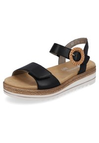 Sandale en cuir noire avec sangle réglable, boucle accent tissée, semelle rembourrée et une semelle blanche superposée avec des détails texturés.
