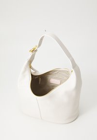 Sac hobo en cuir blanc avec une surface texturée, fermeture éclair dorée et un intérieur doux. Comprend une petite poche intérieure et un doublure en tissu.