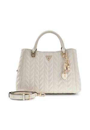 Sac à main matelassé blanc avec poignées supérieures, ferrures dorées, accessoires charms et bandoulière amovible posée à côté.