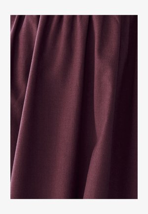 Burgundy fabric with a soft texture, draping in pleats. Smooth finish with no patterns or hardware visible.