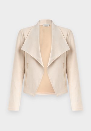 Μπεζ σουέντ μπουφάν με φαρδιές ανοιχτές πέτσες και τσέπες με φερμουάρ στις πλευρές, εκτεθειμένο σε απλό φωτεινό φόντο.