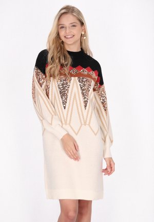 Abito maglione lavorato a maglia con accenti neri e rossi, caratterizzato da un design geometrico in paillettes di oro rosa e crema. Maniche lunghe e polsini a coste.
