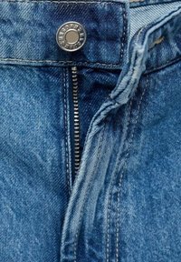 Farkut denim, jotka ovat sinisiä, varustettu vetoketjulla ja nappikiinnityksellä. Näkyvä ompelu ja klassinen 5-taskuinen muotoilu.