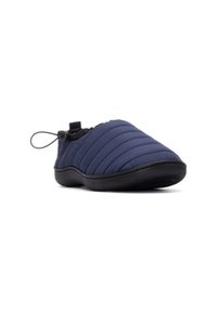 Pantufla acolchada azul marino con cuello elástico, suela de goma negra y cordón ajustable para un ajuste seguro. Superficie texturizada con detalle de costuras.