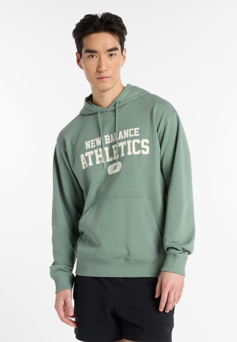 Green hoodie with a kangaroo pocket, featuring white "NEW BALANCE ATHLETICS" text. Soft fabric and loose-fitting design.