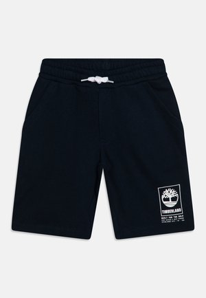 Shorts en coton bleu marine avec taille élastique, cordon de serrage blanc, deux poches latérales et un logo Timberland blanc imprimé sur le bas à gauche.