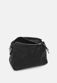 Borsa in pelle nera stampata con due compartimenti con zip, forma arrotondata, motivi decorativi sulla superficie e un accento rotondo in argento.