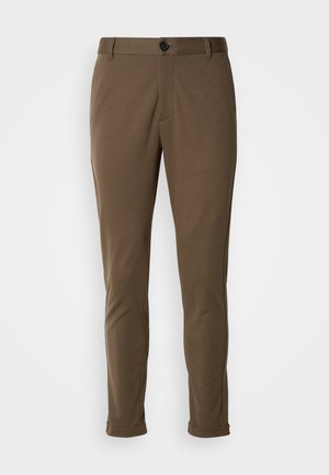 Brune skræddersyede bukser med en glat tekstur, der har en knaplukning og rullede manchetter. Designet med en slim fit og funktionelle lommer.