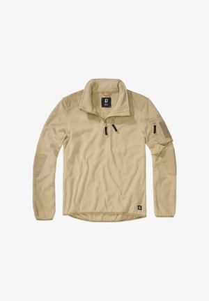 Beżowy polarowy pulower z kołnierzem na zamek do ćwiartki, kieszenią na lewym ramieniu i teksturowanym materiałem na ciele. Posiada metkę z literą "B" na dole po lewej stronie.