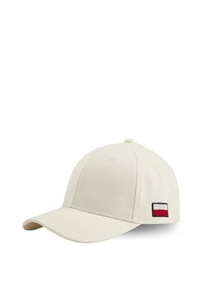 Kremowa czapka baseballowa z małą prostokątną naszywką logo w kolorach czerwonym, białym i granatowym po boku, ukazana na białym tle.