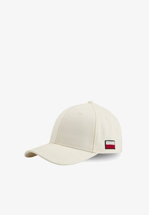 Kremowa czapka baseballowa z małą prostokątną naszywką logo w kolorach czerwonym, białym i granatowym po boku, ukazana na białym tle.