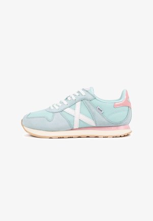 Zapatillas deportivas azul claro con parte superior de ante, detalles de malla blanca, talón rosa y cordones blancos. Presentan un logo en forma de X blanca en el lateral.