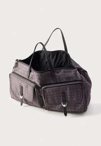 Dark patterned tote bag with two front zipped pockets, black leather straps and buckled flaps, open top showing black interior lining.