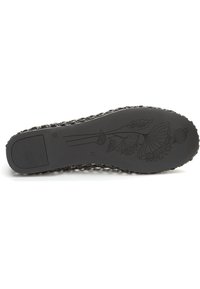 Suela de zapato de goma negra con un borde texturizado, que presenta un patrón floral en relieve y surcos de tracción rectangulares. Talla marcada como 37.