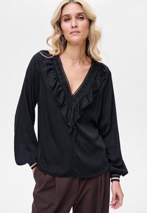 Czarna bluzka z dekoltem w kształcie litery V, zdobiona falbankami i haftem. Długie rękawy zakończone dopasowanymi mankietami, wykonana z miękkiego, gładkiego materiału.