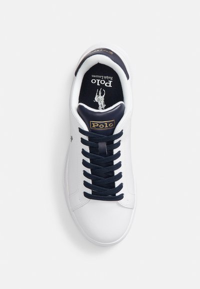 Ténis brancos com parte superior em couro liso, atacadores azul-marinho e uma gola acolchoada. Apresenta um logótipo Polo dourado na língua e um gráfico de cavalo no interior.