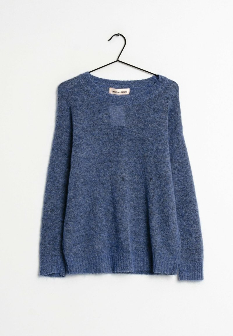 Pull bleu doux à manches longues et col rond suspendu sur un cintre noir contre un fond blanc.