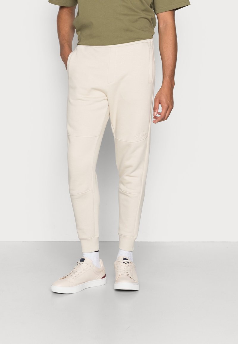 Lichtbeige sweatpants gemaakt van zachte stof, met elastische boorden, zijzakken en een subtiele logo-detail op de dij.