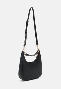 Sac à épaule en cuir noir avec fermeture éclair dorée, bandoulière réglable et clips amovibles, présenté sur fond blanc.