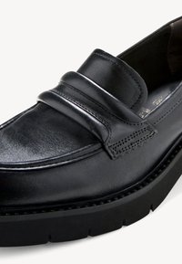 Mocassin en cuir noir avec une finition lisse, détail de double sangle et semelle texturée. Dispose d'un bout rond et d'accents de couture subtils.