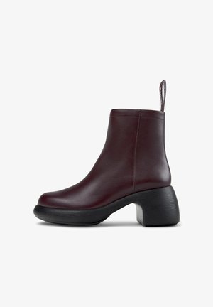 Burgundy leather ankle boots with a smooth finish, round toe, and a chunky black heel. Features a pull tab at the back for easy wear.