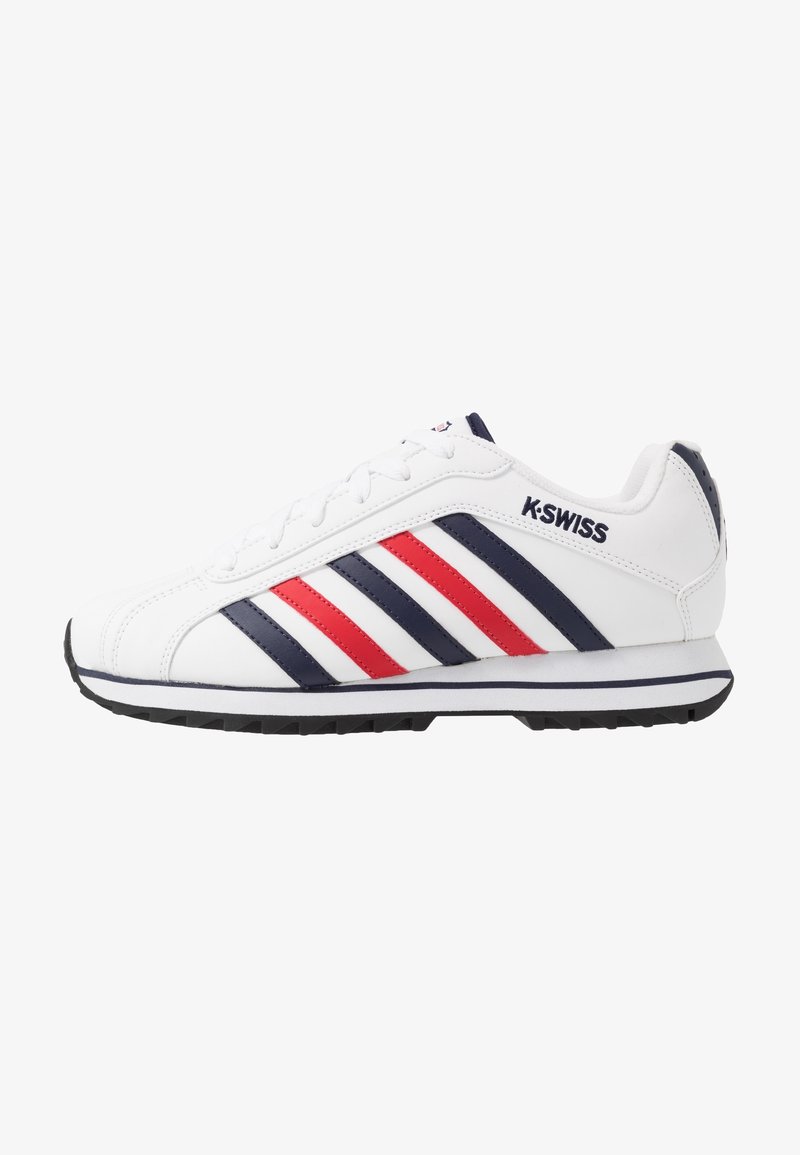 Baskets blanches K-Swiss avec des rayures rouges et bleu marine, lacets blancs et semelle noire, présentées de profil droit sur fond blanc.