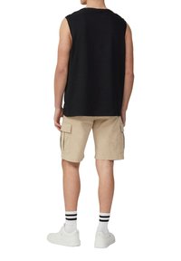 Zwarte mouwloze shirt, beige cargoshorts met zijzakken, witte sneakers en zwart-wit gestreepte sokken. Glad materiaal, comfortabele pasvorm.