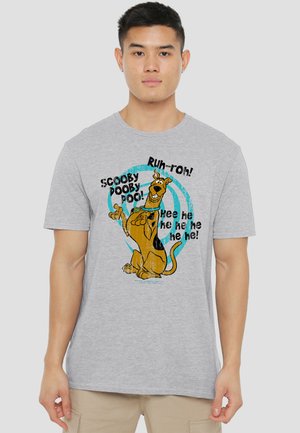 Young man wearing a gray t-shirt with a colorful Scooby-Doo graphic and phrases "Scooby Dooby Doo!" and "Ruh-roh!"