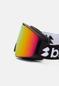 Ski goggles s veľkým, zakriveným sklom s prechodom farieb z zelenej na ružovú. Čierny rám a popruh s bielymi logovými akcentmi. Obsahuje mäkké polstrovanie.
